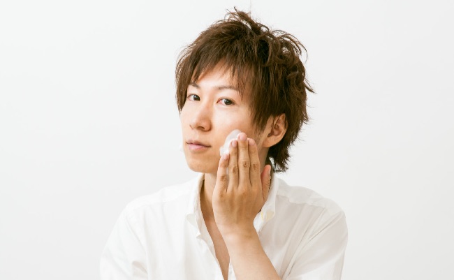 洗顔剤をつける男性