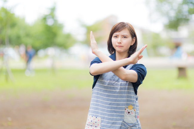 ダメーとバッテンを出す女性