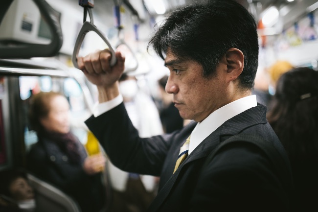 電車で帰宅する男性